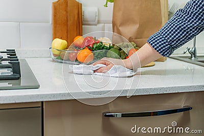 Female hand with a rag cleaning kitchen desk. Microfiber cloth, absorbent towels, reuseable cloth for Kitchen Cleaning Stock Photo