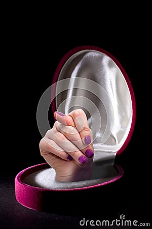 Female Hand with Red Nails in Jewelry Box Showing a Fig Sign, Meaning Don't Believe in Promises. Isolated on Black Stock Photo