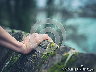 Female hand resting on stone wall Stock Photo