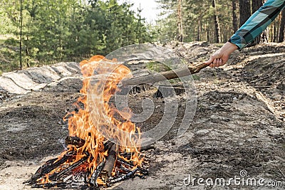 Female hand throws firewood in the fire Stock Photo