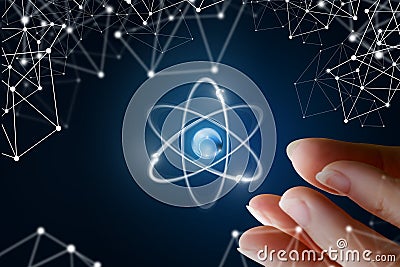 Female hand show the atom . Stock Photo