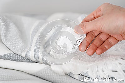 Female hand showing label on clothes, closeup Stock Photo