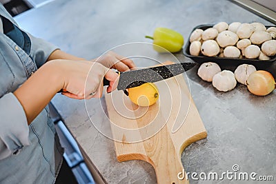 Female hand slicing lemon with knife Stock Photo