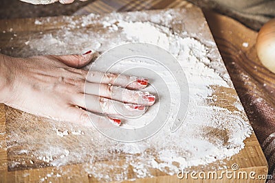 Female hand smoothes flour on board Stock Photo