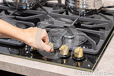 Female hand turn on gas stove Stock Photo