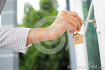 The female hand is using the key to open his own house. New home, home and homeownership concept Stock Photo