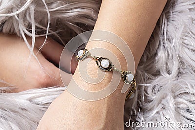 wrist wearing brass golden bracelet with mineral stone Stock Photo