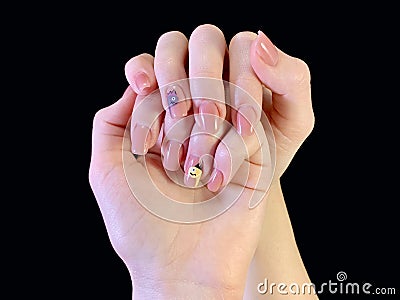 Female hands with a beautiful manicure, on a black background. Hands of a young girl, with manicured nails. The fingers of a young Stock Photo