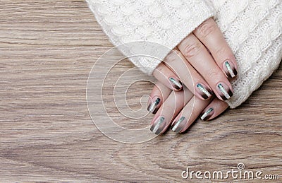 Female hands with black manicure on a wooden background Stock Photo