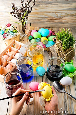 Female hands coloring eggs for Easter holiday Stock Photo