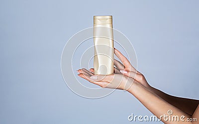 Female hands with cosmetic bottle. Hands holding bottle of hair conditioner. Female hand with cosmetics bottles. Shampoo Stock Photo