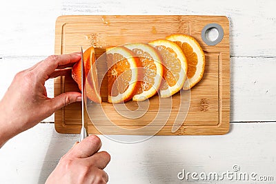 Female hands cut fresh orange. Juicy and with vitamins Stock Photo