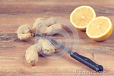 Female hands cut into pieces ginger root for a drink made from fresh lemon and ginger Stock Photo