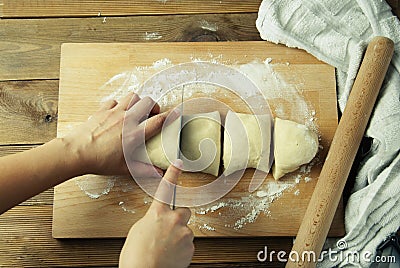 Female Hands cutting Dough for baking pie, or pizza. Homemade Preparing Food. Top view. Rustic background. Stock Photo