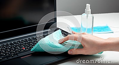 Female hands disinfecting laptop keyboard using Disinfectant spray, Alcohol sanitizer, wet disinfectant wipes. Woman cleaning Stock Photo