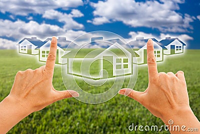 Female Hands Framing Houses Over Grass and Sky Stock Photo