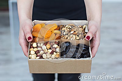 Female hands hold a box of nuts Stock Photo