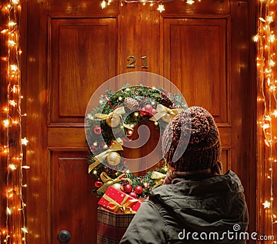 Female hands hold gift boxes in front of the door. Magic on Christmas eve Stock Photo