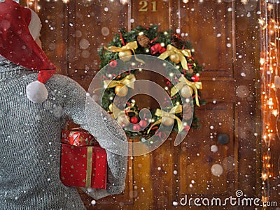 Female hands hold gift boxes in front of the door. Magic on Christmas night Stock Photo