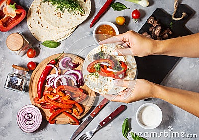 Female hands hold mexican tacos on concrete background. Cooking. Stock Photo