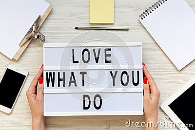 Female hands hold modern board with `Love what you do` word over Stock Photo