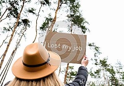 Female hands holding cardboard with text LOST MY JOB outdoors. Nature background. Protester activist Stock Photo