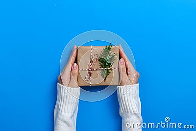 Female hands holding gift box on Blue background Stock Photo