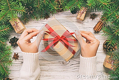 Female hands holding handmade present box in recycled paper on white wooden table background. christmas preparation concept, Gift Stock Photo