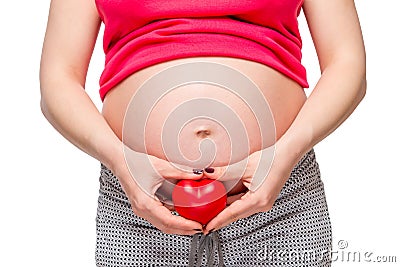 female hands holding a loving heart at the abdomen level Stock Photo