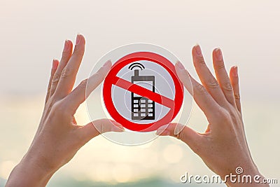 Female hands holding No phone calls sign on the beach Stock Photo