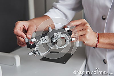 Female hands holding the optical device for eye testing Stock Photo