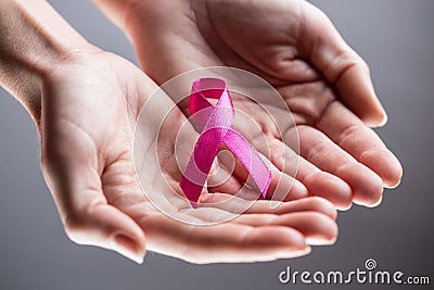 Female hands holding pink ribbon, breast cancer concept Stock Photo