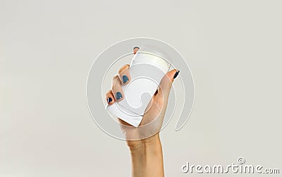 Female hands holding white deodorant. Isolated on gray background. Closeup Stock Photo