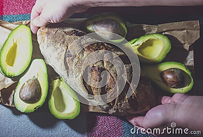Female hands laying bread near the avocado. Stock Photo