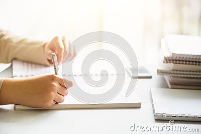 Female hands with pen writing on notebook. Back to school concept. Student from university learning languages Stock Photo