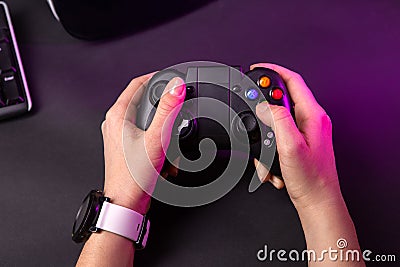 Female hands playing a computer game with a game joystick. Stock Photo