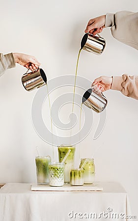 Female hands pouring matcha tea to milk for matcha latte Stock Photo