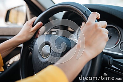 Female hands on steering wheel while driving a car Stock Photo