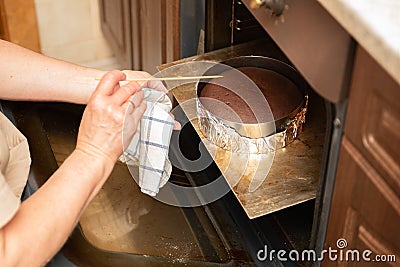 Female hands take out a finished chocolate biscuit from the oven. homemade baking Stock Photo