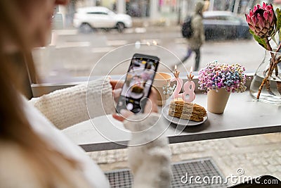 Female hands take a photo of a piece of cake with candles Stock Photo