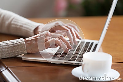 Female hands typing on keyboard, senior woman working on laptop Stock Photo