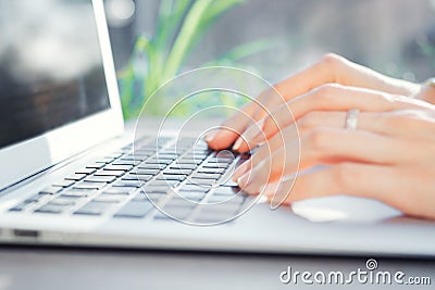 Female hands typing on the laptop keyboard close up. Woman work at computer Stock Photo