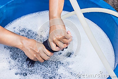 Female hands wash clothing by hand with detergent in basin. selective focus and space for text. Stock Photo
