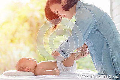 Female hands wearing pants for baby Stock Photo