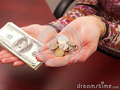 Female hands weigh coins and denominations. Stock Photo