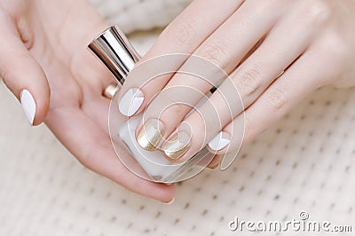 Female hands with white and gold nail design Stock Photo