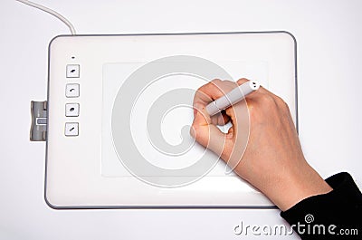 Female hands work on a graphic tablet. Hand holds stylus pen and draws. White graphic tablet. The work of a graphic designer. Girl Stock Photo