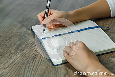 Female hands are writing in a notebook Stock Photo