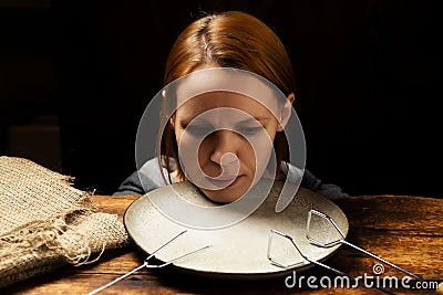 Female head on a plate on a dark background. Fear of diet, apathy concept Stock Photo