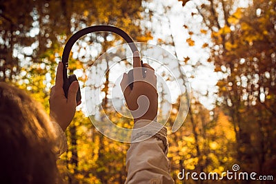 Female with headphones walking on the park listen sounds or music of autumn forest. Concept. Indian summer season Stock Photo
